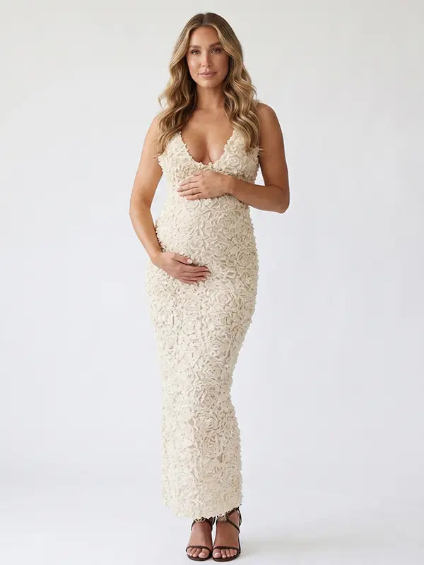 Ivory 3D rosette floral maternity maxi dress featuring a deep V neckline, textured floral fabric, bodycon pregnancy silhouette, and elegant design for luxury maternity photoshoots, baby showers, bridal maternity sessions, and timeless pregnancy portraits.