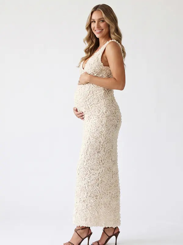 Ivory 3D rosette floral maternity maxi dress featuring a deep V neckline, textured floral fabric, bodycon pregnancy silhouette, and elegant design for luxury maternity photoshoots, baby showers, bridal maternity sessions, and timeless pregnancy portraits.