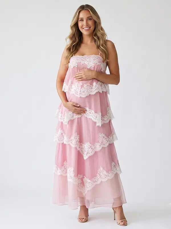 A pink tiered lace maternity maxi dress with layered chiffon, white lace trim, and an adjustable lace-up back for baby shower, maternity photoshoot, gender reveal, and bridal shower.