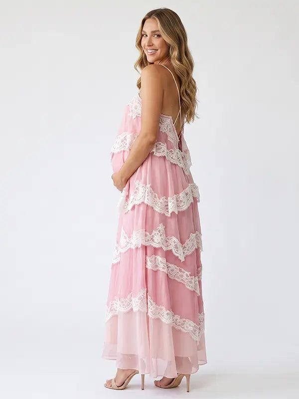 A pink tiered lace maternity maxi dress with layered chiffon, white lace trim, and an adjustable lace-up back for baby shower, maternity photoshoot, gender reveal, and bridal shower.
