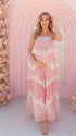 A pink tiered lace maternity maxi dress with layered chiffon, white lace trim, and an adjustable lace-up back for baby shower, maternity photoshoot, gender reveal, and bridal shower.