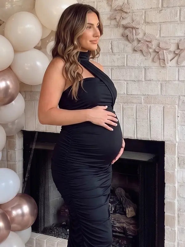 black halter maternity maxi dress with ruched bodycon silhouette and cross neck detail