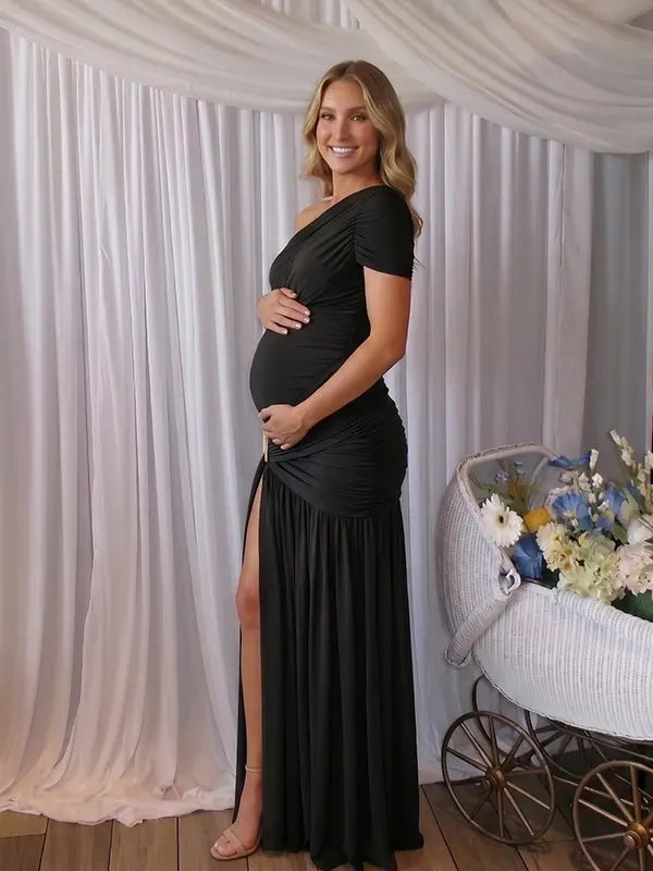 Black one shoulder maternity gown with ruched silhouette and high slit for elegant pregnancy photoshoots