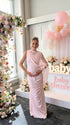 Pregnant woman wearing blush pink one shoulder draped maternity maxi dress for baby shower photoshoot