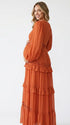 burnt orange lace trim maternity maxi dress with long sleeves and flowing tiered skirt