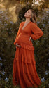 burnt orange lace trim maternity maxi dress with long sleeves and flowing tiered skirt