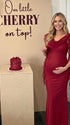 burgundy mesh maternity gown with draped neckline and cascading ruffle details