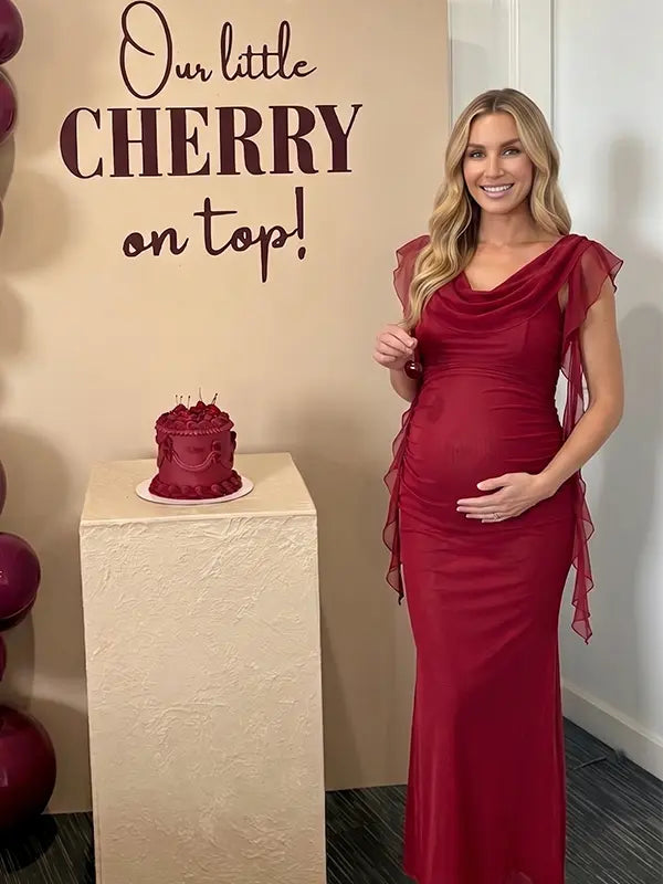 burgundy mesh maternity gown with draped neckline and cascading ruffle details