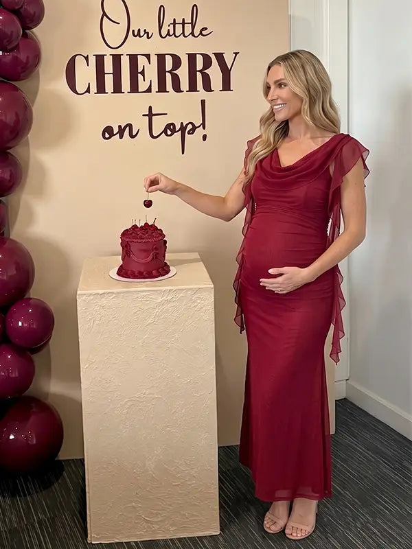 burgundy mesh maternity gown with draped neckline and cascading ruffle details