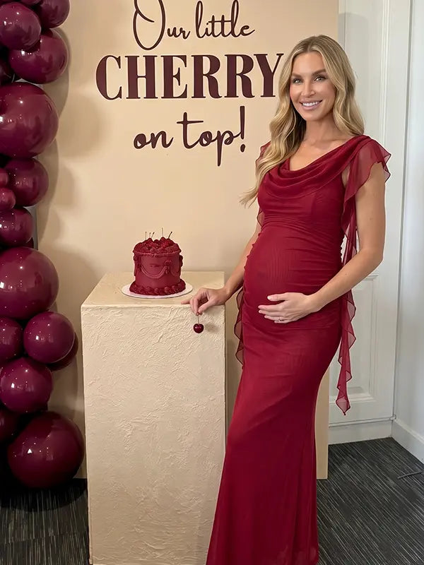 burgundy mesh maternity gown with draped neckline and cascading ruffle details