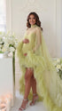 Shop this butter yellow maternity photoshoot cape with sheer tulle, dramatic feather trim and a flowing train. A statement piece for pregnancy portraits.