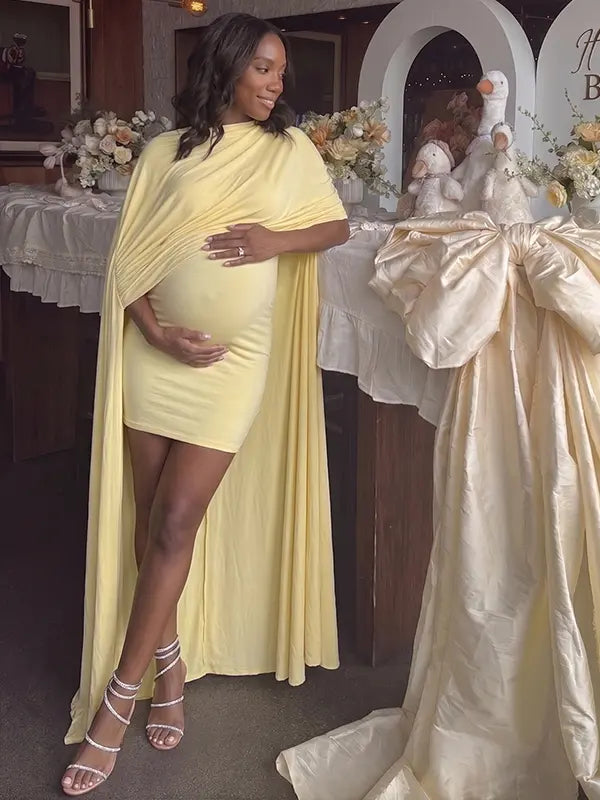butter yellow maternity cape dress with bodycon mini silhouette and dramatic flowing drape