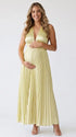 Pregnant model wearing a butter yellow pleated satin halter maternity maxi dress with deep V neckline and flowing skirt for summer baby shower, garden party and maternity photoshoot.