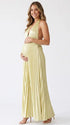 Pregnant model wearing a butter yellow pleated satin halter maternity maxi dress with deep V neckline and flowing skirt for summer baby shower, garden party and maternity photoshoot.