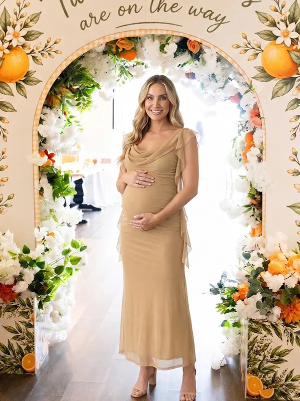 champagne beige maternity gown with draped neckline and cascading mesh ruffle details