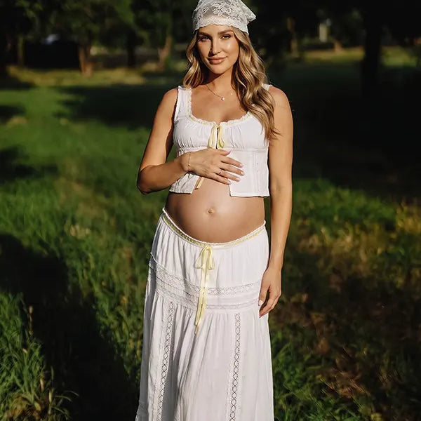 Ivory Boho Lace Two Piece Maternity Photoshoot Outfit Featuring a Tie Front Crop Top and Flowing Tiered Maxi Skirt for Boho Pregnancy Photography, Beach Maternity Sessions and Pregnancy Announcements | Bumplook