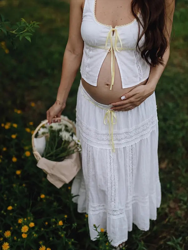 Ivory Boho Lace Two Piece Maternity Photoshoot Outfit Featuring a Tie Front Crop Top and Flowing Tiered Maxi Skirt for Boho Pregnancy Photography, Beach Maternity Sessions and Pregnancy Announcements | Bumplook