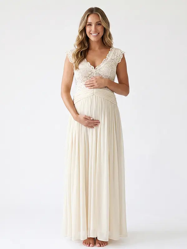 Pregnant model wearing an ivory lace chiffon maternity maxi dress with floral lace bodice, flutter sleeves and flowing skirt for boho baby shower, maternity photoshoot and bridal celebration.