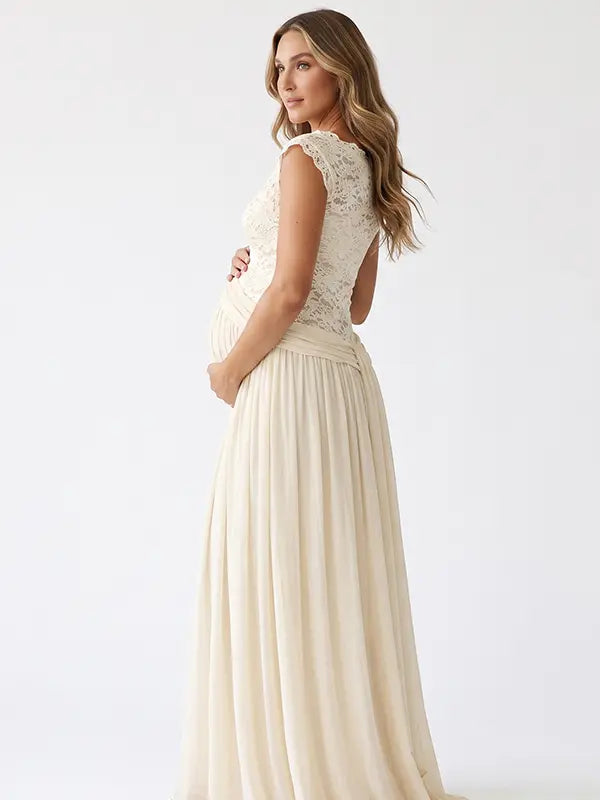 An ivory lace chiffon maternity maxi dress with floral lace bodice, flutter sleeves and flowing skirt for boho baby shower, maternity photoshoot and bridal celebration.