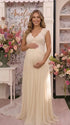 An ivory lace chiffon maternity maxi dress with floral lace bodice, flutter sleeves and flowing skirt for boho baby shower, maternity photoshoot and bridal celebration.