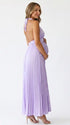 Pregnant model wearing a lavender pleated satin halter maternity maxi dress with deep V neckline and flowing skirt for spring baby shower, garden party and maternity photoshoot.