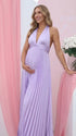 Pregnant model wearing a lavender pleated satin halter maternity maxi dress with deep V neckline and flowing skirt for spring baby shower, garden party and maternity photoshoot.