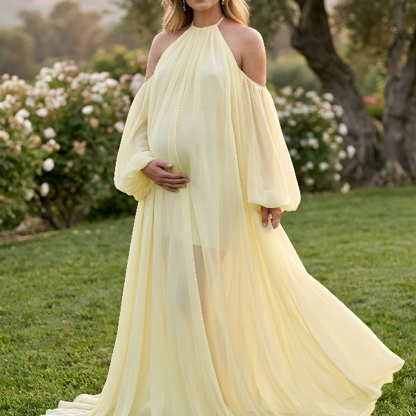 Pregnant woman wearing romantic light yellow maternity gown outdoors