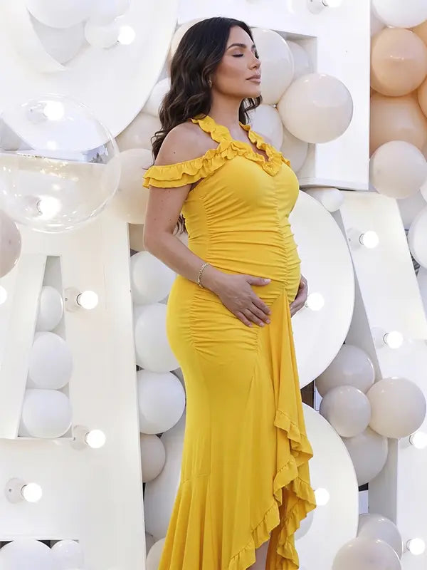 Mustard yellow ruffle halter maternity maxi dress with ruched bodycon silhouette and flowing high-low hem