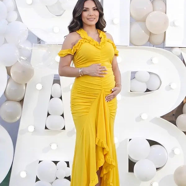 Mustard yellow ruffle halter maternity maxi dress with ruched bodycon silhouette and flowing high-low hem
