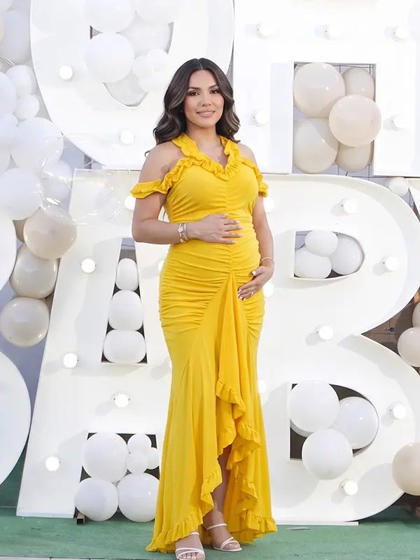 Mustard yellow ruffle halter maternity maxi dress with ruched bodycon silhouette and flowing high-low hem