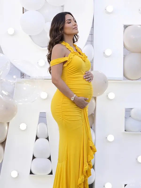 Mustard yellow ruffle halter maternity maxi dress with ruched bodycon silhouette and flowing high-low hem
