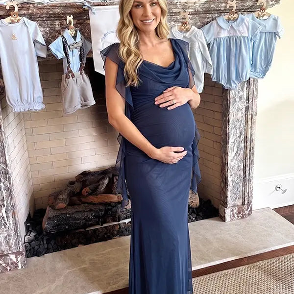 navy blue mesh maternity gown with draped neckline and cascading ruffle details
