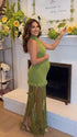 Olive green fringe halter maternity maxi dress with tassel hem, bodycon pregnancy gown for boho baby shower, rustic maternity photoshoot, outdoor pregnancy photography, and nature-inspired maternity portraits.
