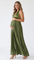 Pregnant model wearing an olive green pleated satin halter maternity maxi dress with deep V neckline and flowing skirt for boho baby shower, rustic maternity photoshoot and outdoor pregnancy celebration.