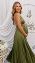 Pregnant model wearing an olive green pleated satin halter maternity maxi dress with deep V neckline and flowing skirt for boho baby shower, rustic maternity photoshoot and outdoor pregnancy celebration.