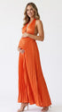 Pregnant model wearing an orange pleated satin halter maternity maxi dress with deep V neckline and flowing skirt for fall baby shower, pumpkin patch photos and maternity photography.