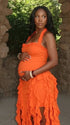 orange ruffle maternity dress with halter neckline and asymmetrical frill hem