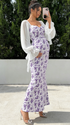 Pregnant woman wearing romantic purple floral maternity dress outdoors