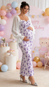 Side view of pregnant woman wearing purple floral maternity maxi dress for baby shower