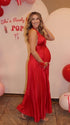 Pregnant model wearing a red pleated satin halter maternity maxi dress with deep V neckline, empire waist and flowing skirt for baby shower, gender reveal and maternity photoshoot.
