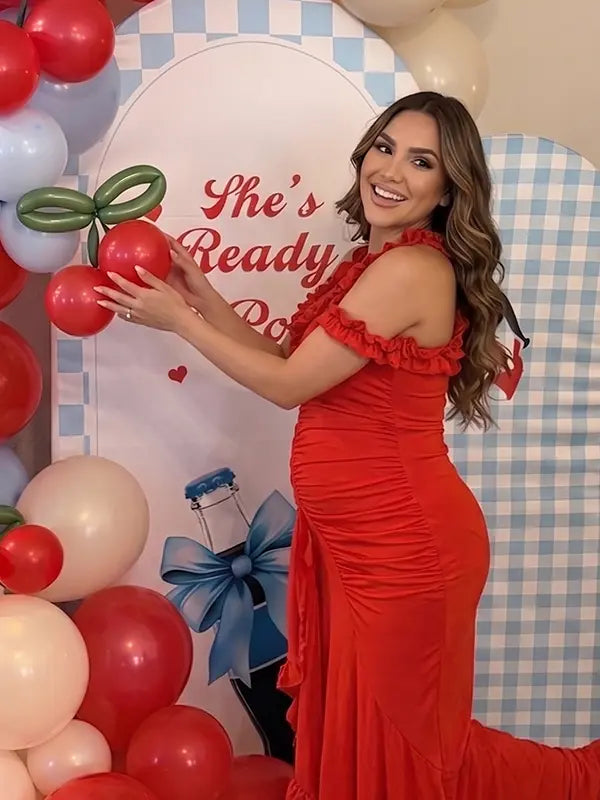 Red ruffle halter maternity maxi dress with ruched bodycon fit and flowing high-low hem