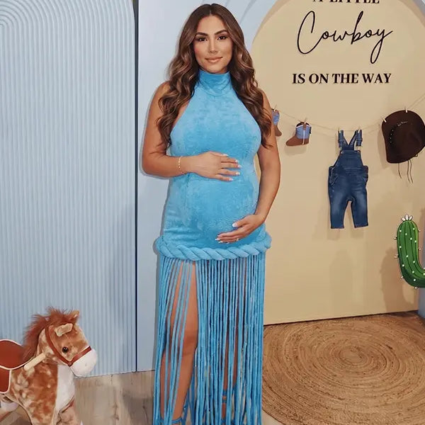 Sky blue fringe halter maternity maxi dress with tassel hem, bodycon pregnancy gown for boho baby shower, maternity photoshoot, western maternity photography, festival-inspired pregnancy portraits.