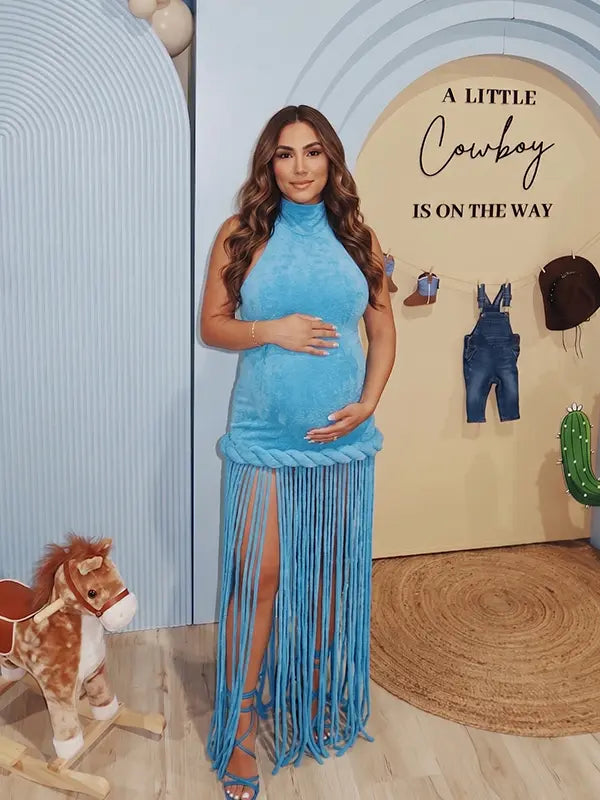 Sky blue fringe halter maternity maxi dress with tassel hem, bodycon pregnancy gown for boho baby shower, maternity photoshoot, western maternity photography, festival-inspired pregnancy portraits.