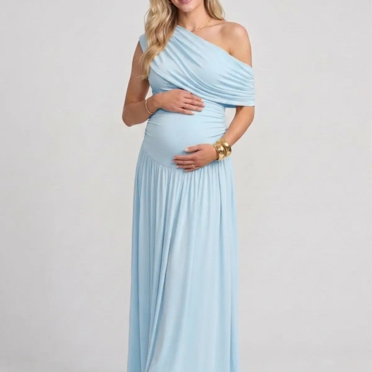 Pregnant woman in a sky blue off-the-shoulder poly-spandex maternity maxi dress with ruched detailing.