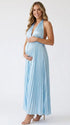 Pregnant model wearing a sky blue pleated satin halter maternity maxi dress with deep V neckline and flowing skirt for beach maternity photoshoot, coastal baby shower and destination pregnancy photography.