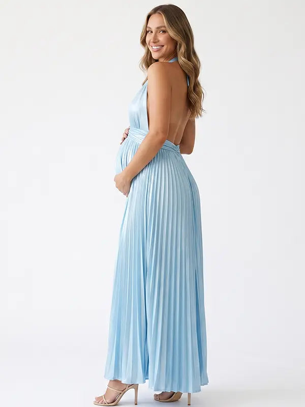 Pregnant model wearing a sky blue pleated satin halter maternity maxi dress with deep V neckline and flowing skirt for beach maternity photoshoot, coastal baby shower and destination pregnancy photography.