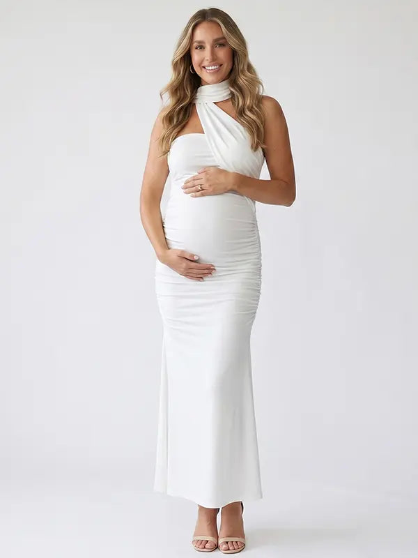 white halter maternity maxi dress with ruched bodycon silhouette and cross neck detail