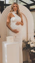 white halter maternity maxi dress with ruched bodycon silhouette and cross neck detail