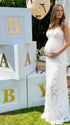 Pregnant woman wearing white floral open back maternity dress for baby shower