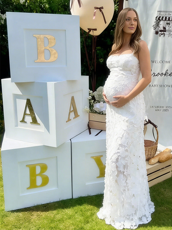 Pregnant woman wearing white floral open back maternity dress for baby shower